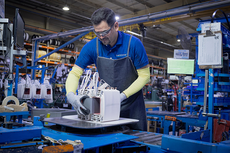 industrial worker inserts transformer core
